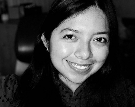 black and white picture of a person with smile dark hair dark eyes looking into camera close up